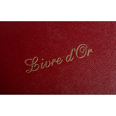 Livre rouge en cuir avec inscription dorée : 'Livre d'Or'.
