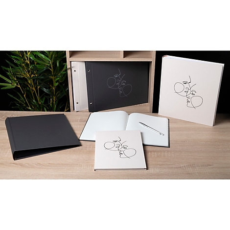 Plusieurs carnets et blocs-notes noirs et crème disposés sur un bureau en bois, avec un dessin au trait de visages.