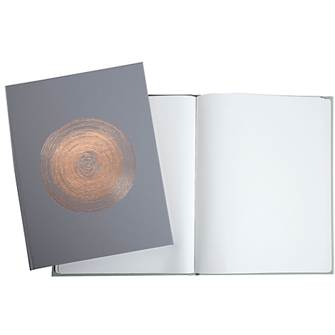 Un cahier gris avec un motif circulaire cuivré sur la couverture. Les pages sont vierges et blanches.