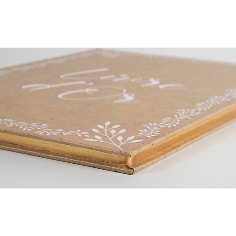 Gros plan d'un livre avec l'inscription "Amour" et des décorations florales. Couverture marron avec des pages dorées.