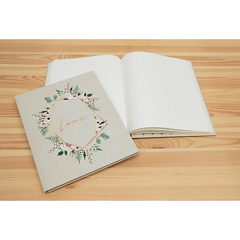 Un carnet ouvert et un carnet fermé avec un motif floral et le mot "Love" sur une table en bois.