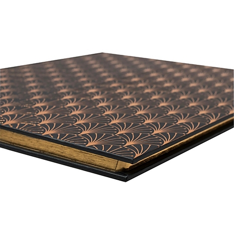 Gros plan d'un livre avec une couverture noire et un motif doré. Les pages sont dorées, la tranche du livre est visible.