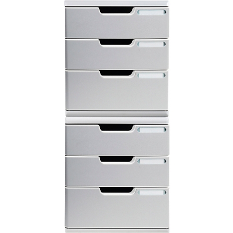 Grauer, hoher Schubladenschrank mit sechs Schubladen. Jede Schublade hat einen dunklen Griff und eine helle Beschriftung.