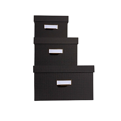 Drei schwarze Boxen mit silbernen Etiketten, gestapelt auf weißem Hintergrund.