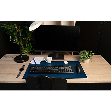 Büroarbeitsplatz mit Schreibtisch, Monitor, Tastatur, Maus, Lampe, Uhr und Pflanze.
