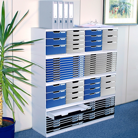 Weisses Büroregal mit Schubladen in Blau, Grau und Schwarz. Oben liegen Ordner, links eine Pflanze.
