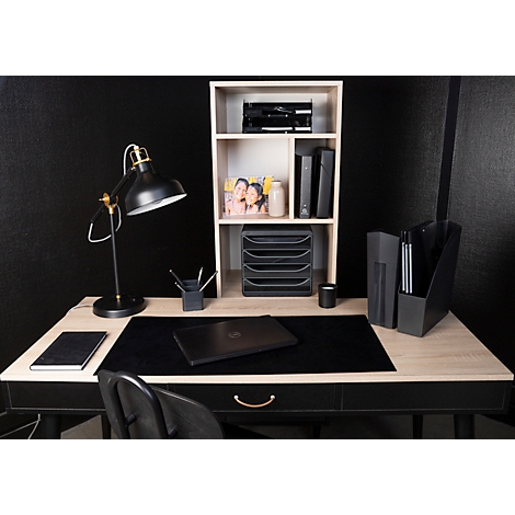 Schreibtisch mit Laptop, Lampe, Bücherregal, schwarzem Tischläufer und Stuhl. Dekoriert mit Zeitschriften, Bechern und Ordnern.