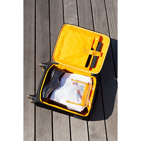 Geöffnete, gelb gefütterte, schwarze Handgepäck-Trolley. Darin ein Schuh, Beutel, Utensilien.