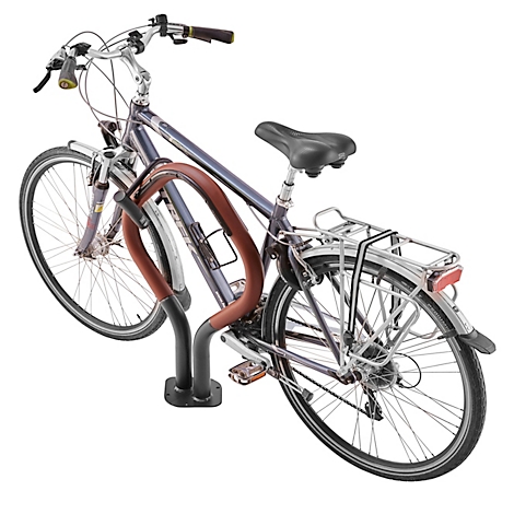 Fahrrad steht in einem Fahrradständer aus Stahl, in Lila-Tönen und Braun.