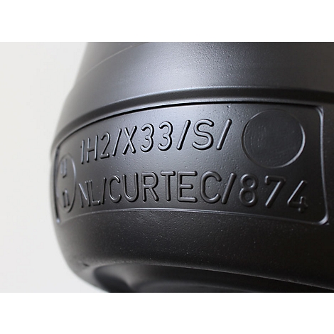 Nahaufnahme eines schwarzen Kunststoffbehälters mit eingravierter Schrift: IH2/X33/S/ NL/CURTEC/874.