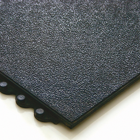 Close-up of a black rubber floor tile with textured surface and connector pins on the edges.