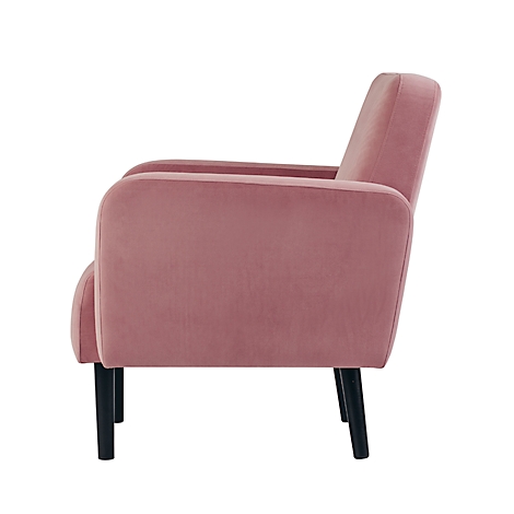 Vue latérale d'un fauteuil en velours rose. Avec des pieds noirs, des accoudoirs et un dossier clairs. Se tient sur un fond blanc.