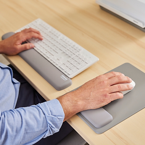 Grijs muismat met polssteun en zwarte muis. Fellowes-logo rechtsboven.