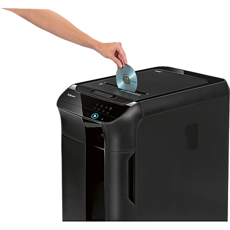 Une main insère un CD dans un destructeur de documents noir.