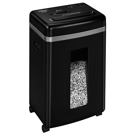 Black paper shredder with paper scraps in the collection container. Input slot on top.