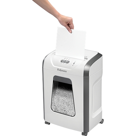 White paper shredder, person inserting a sheet of paper. Gray accents, shredded paper visible in the window.