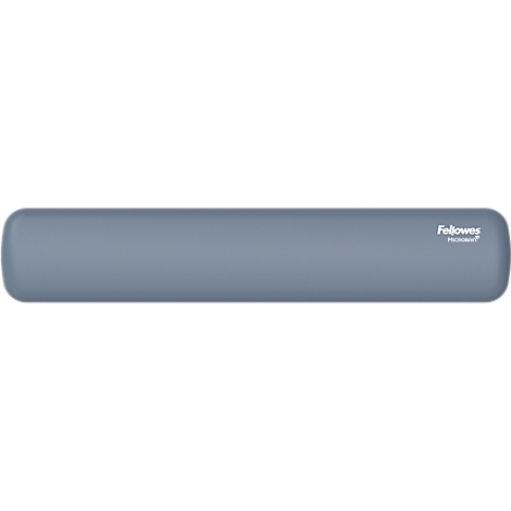 Un homme est assis à un bureau réglable en hauteur, regardant sur le côté. Il porte une chemise bleue et un pantalon bleu foncé.