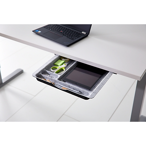 Eine geöffnete Schreibtischschublade mit Stiften, einer Schere, Haftnotizen und einem Tablet.
