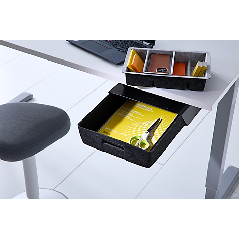 Ausziehbare Schublade unter einem Schreibtisch mit Notizblock und Schere, daneben ein Organizer auf dem Tisch.