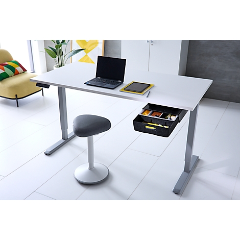 Ein weißer, höhenverstellbarer Schreibtisch mit schwarzer Schublade, Laptop und grauem Stehhocker im hellen Raum.