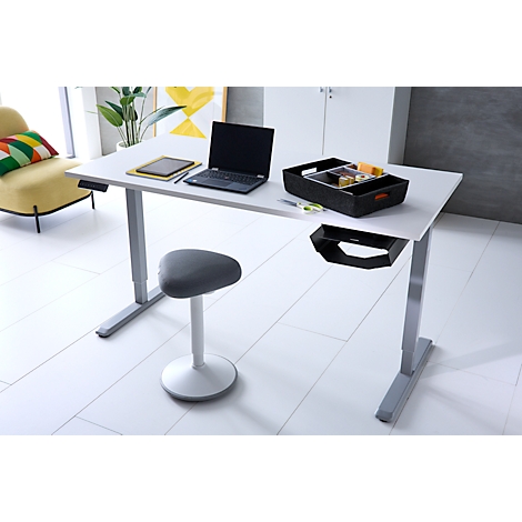 Ein moderner, höhenverstellbarer Schreibtisch mit Laptop und Ordnungsbox in einem hellen Büro.