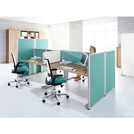 Office with desks, chairs and partitions. A person is sitting at the computer. The decor is turquoise and wood.