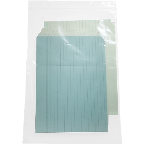 Sheets of paper with blue lines in plastic packaging. Several green and blue sheets can be seen behind a transparent foil.