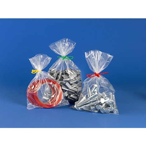 Three transparent bags filled with screws and rubber rings, closed with yellow, green and red strings.