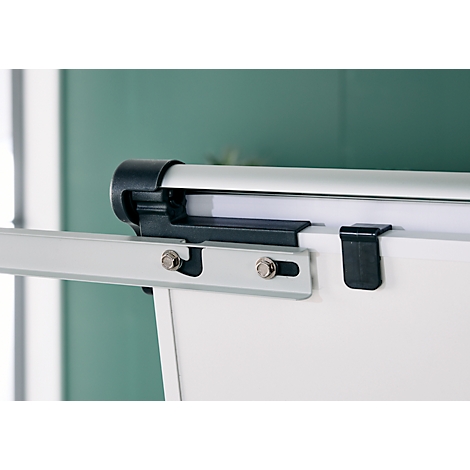 Close-up van een whiteboard met montage en zilveren stang. Op wit papier een zwarte houder.