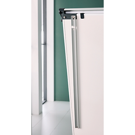 Close-up van een wit whiteboard, deels verborgen door een metalen frame, tegen een groene muur.