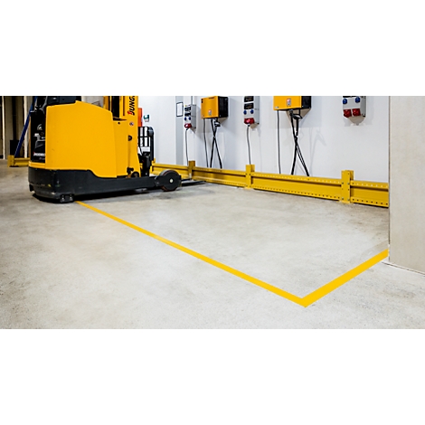 Yellow forklift in a warehouse, marked by yellow lines on the floor.