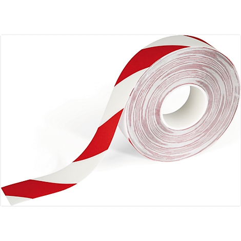 A roll of red and white striped warning tape. The tape is coming off and lies in front of the roll core.