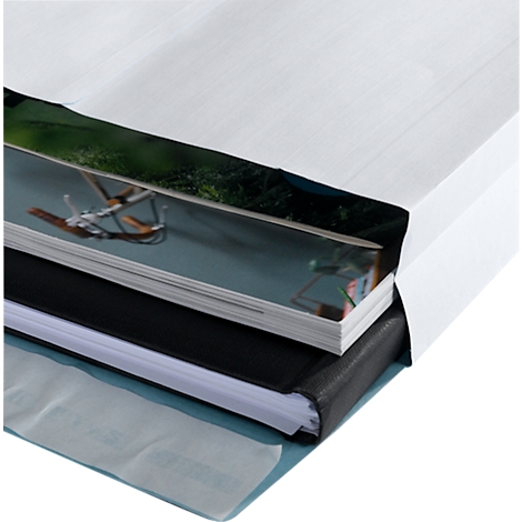 Close-up of a book with different layers of paper inserted in a white cover.