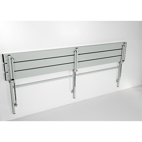 Grey, wall-mounted folding seat, made of metal. Three horizontal seat surfaces, attached to gray wall.