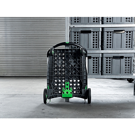 Black transport cart with green accents, standing in front of gray storage boxes. Wheels and handle are visible.