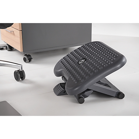 Gray footrest in front of office furniture. Nipple-covered surface, logo.