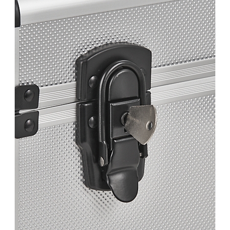 Close-up of a silver suitcase with a black clasp and a key.