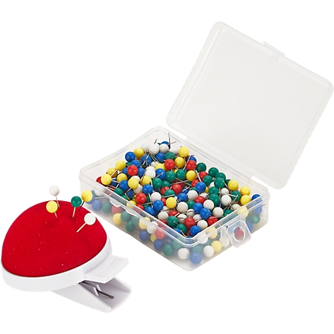 A transparent plastic box with colorful push pins; next to it a red cushion with push pins.