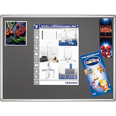 Grey magnetic board with various objects: pictures of vegetables, a brochure and advertising.