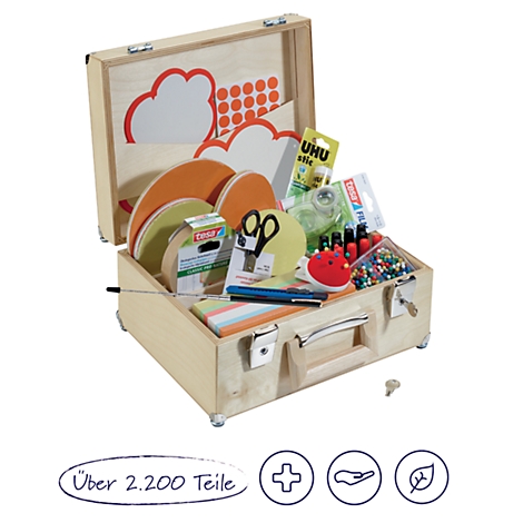 Open houten koffer met knutselspullen zoals schaar, lijm, papier, knopen, speldenkussen en pennen. De koffer staat op een lichte ondergrond.