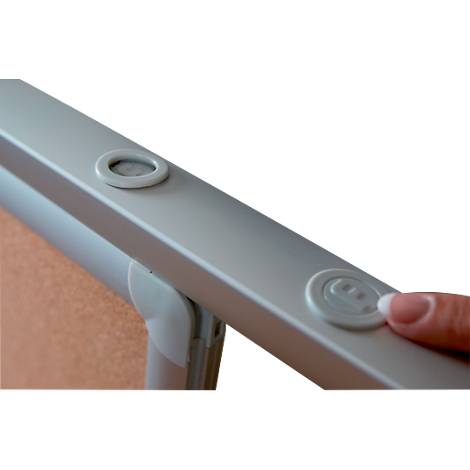 Close-up: Finger pressing a white button on a light grey frame.