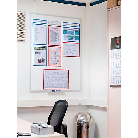 An office corner with whiteboard, chair, trash can, and calendar. The whiteboard has several information boards on it.