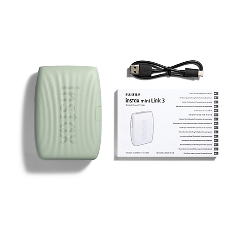 Hellgrüner instax mini Link 3 Smartphone-Drucker, Ladekabel und Bedienungsanleitung vor weißem Hintergrund.