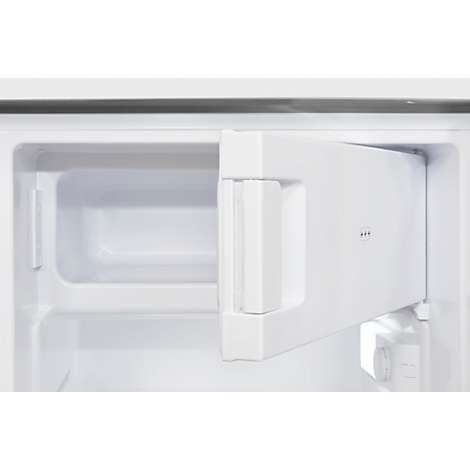 White fridge, open door, underneath a small drawer. A recess on the left.