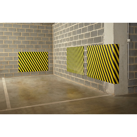 Geel-zwarte waarschuwingsborden op grijze muur. Markering in parkeergarage.