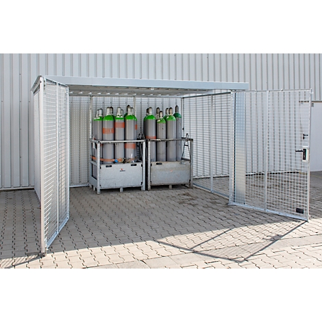 Sichere Gasflaschen im metallenen Schutzhaus. Gittertüren geöffnet, dahinter Flaschen in Transportgestellen.
