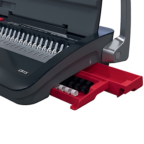 Detailaufnahme einer schwarzen Bindemaschine mit roter Schublade, gefüllt mit schwarzen und weißen Ringen.