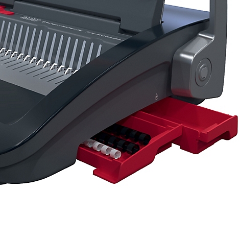 Detailaufnahme einer schwarzen und grauen Bindemaschine mit roter Schublade. In der Schublade liegen verschiedene Binderinge.