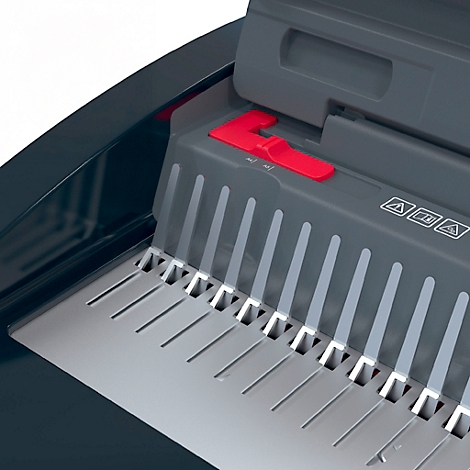 Detailopname van een grijze papierversnipperaar, met focus op de rode schakelaar en metalen elementen.