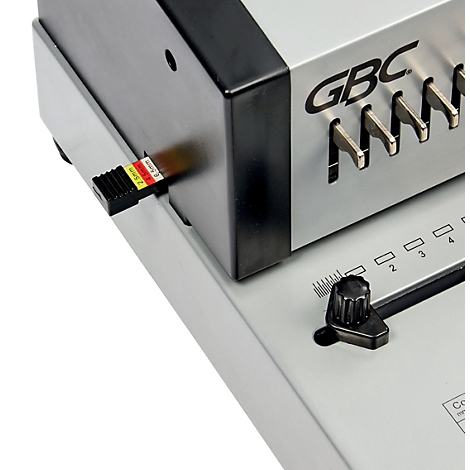 Detailaufnahme einer silbernen GBC-Bindemaschine. Sichtbar sind das Bedienfeld, ein schwarzer Drehkopf und ein Papierstärkemaß.